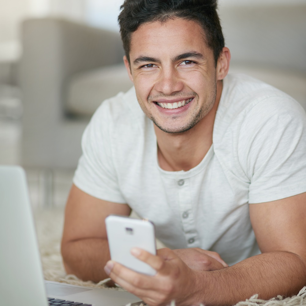 Portrait of a relaxed young man using a phone and JHRWE59.jpg