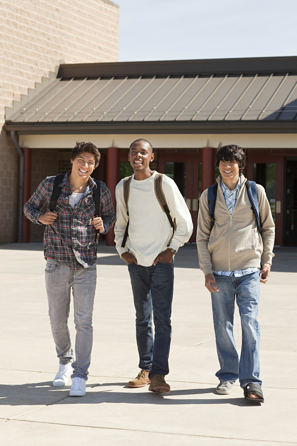 Three friends laughing and walking together outsid RYJSKDE.jpg